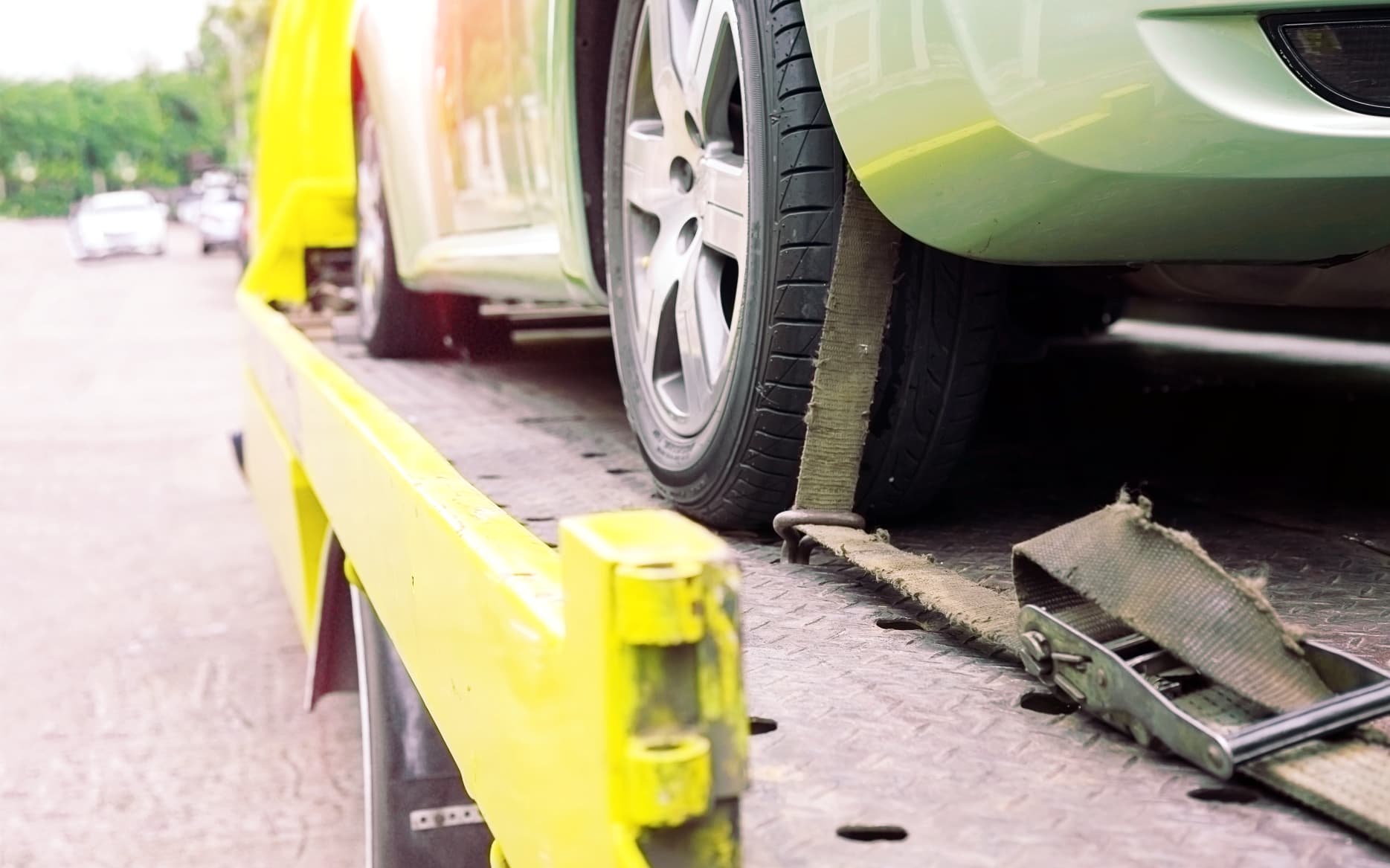 24/7 vehicle recovery services with advanced tracking technology Recovery specialist using flashlight to locate hidden tracking device on stolen vehicle